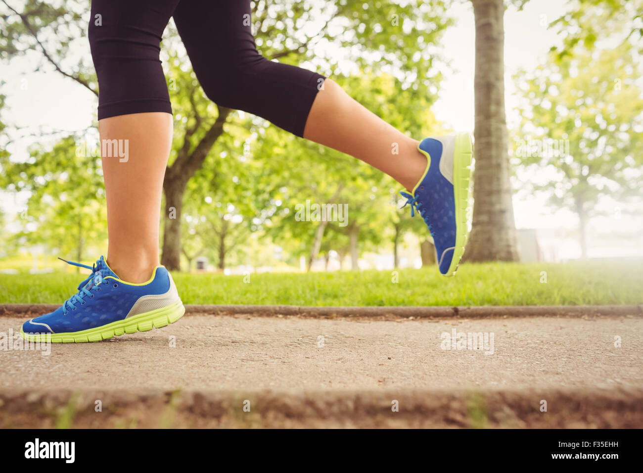 Frau trägt Sportschuhe im Park Joggen Stockfoto