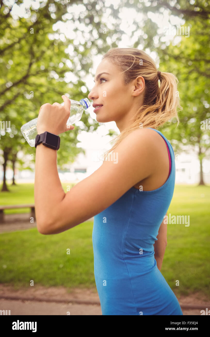 Lächelnde Jogger Frau Trinkwasser Stockfoto