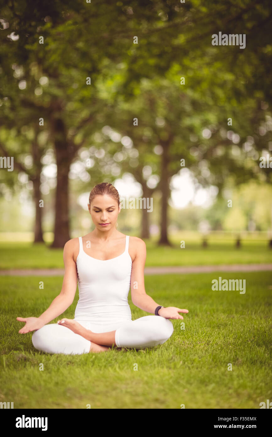 Gesamte Länge der Frau mit Augen geschlossen während der Sitzung in Lotus pose Stockfoto