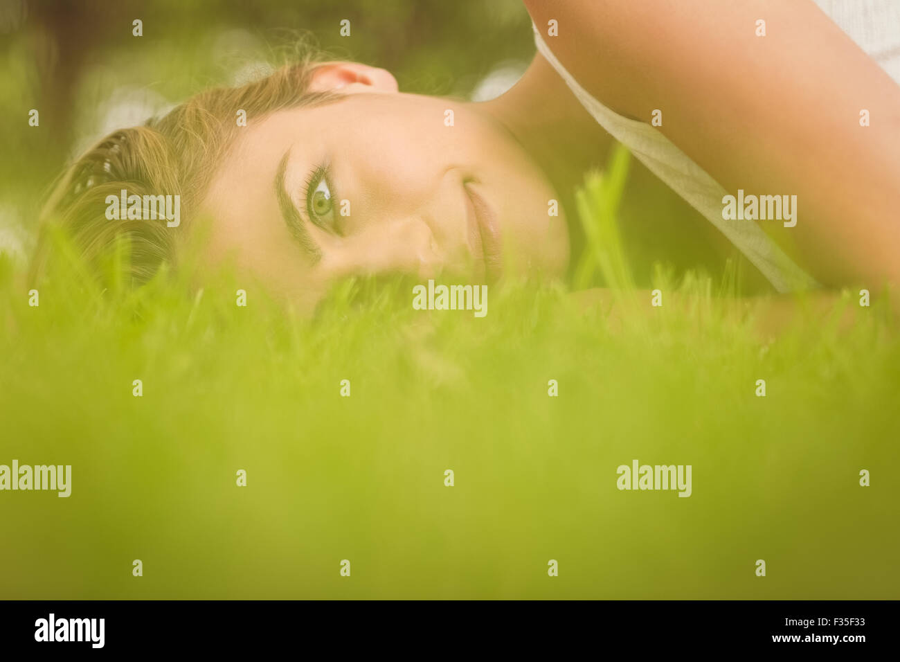 Seitenansicht des schönen lächelnde Frau liegend auf dem Rasen Stockfoto
