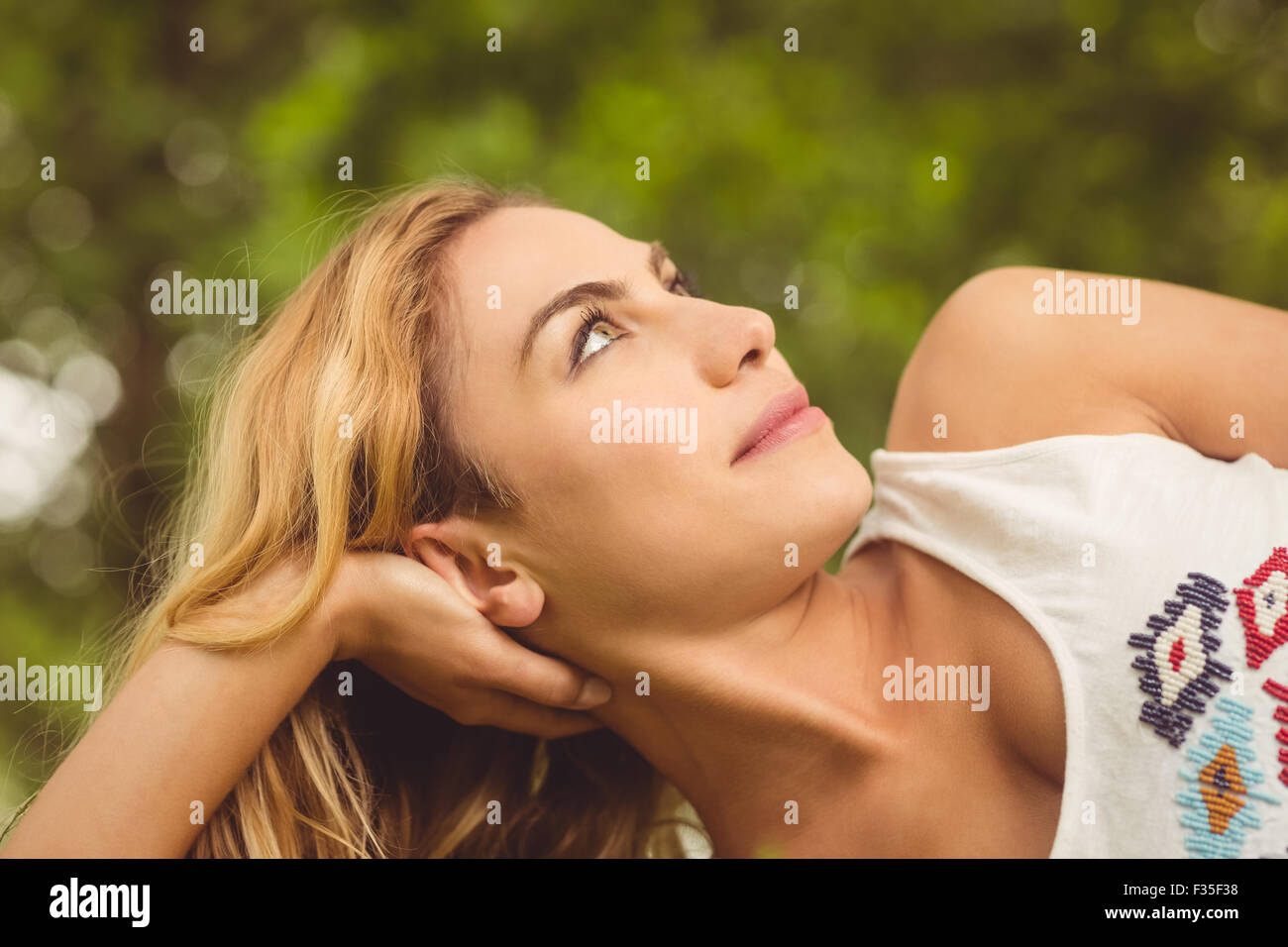 Lächelnde Frau liegen im park Stockfoto