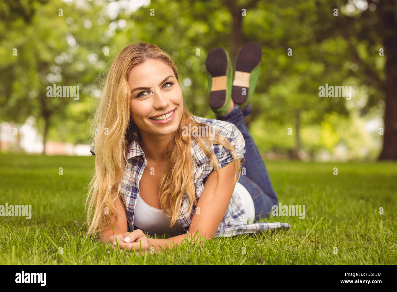 Porträt von lächelnden Frau liegend auf Vorderseite im park Stockfoto
