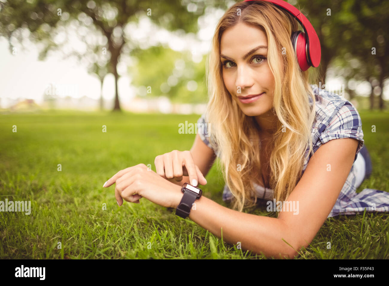 Porträt der lächelnde Frau, Musik hören und berühren Armbanduhr Stockfoto