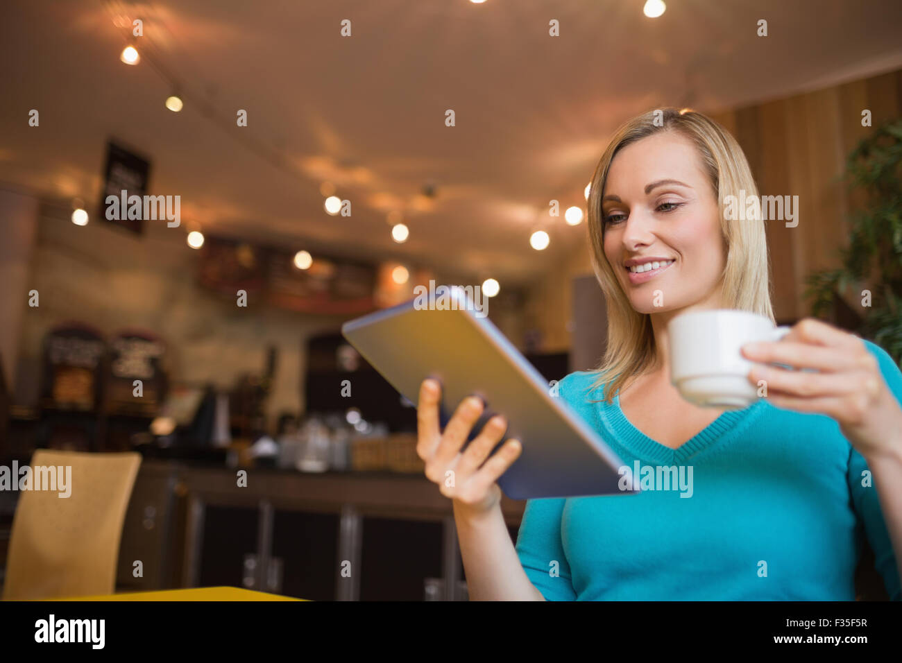 Junge Frau mit digital-Tablette Tasse mit gedrückter Stockfoto