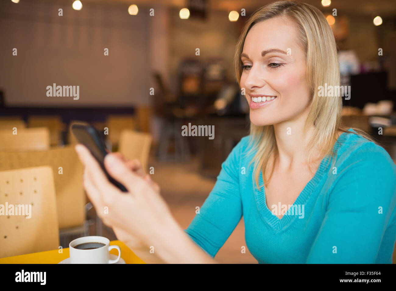 Junge Frau lächelnd mit Handy Stockfoto