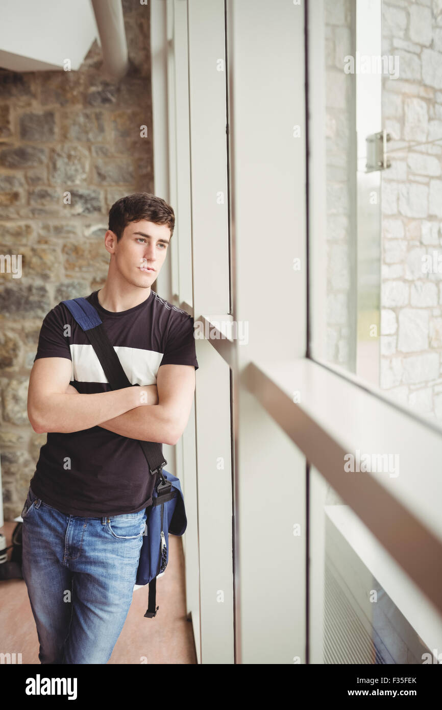 Nachdenklich männlichen Studenten mit verschränkten Armen Stockfoto
