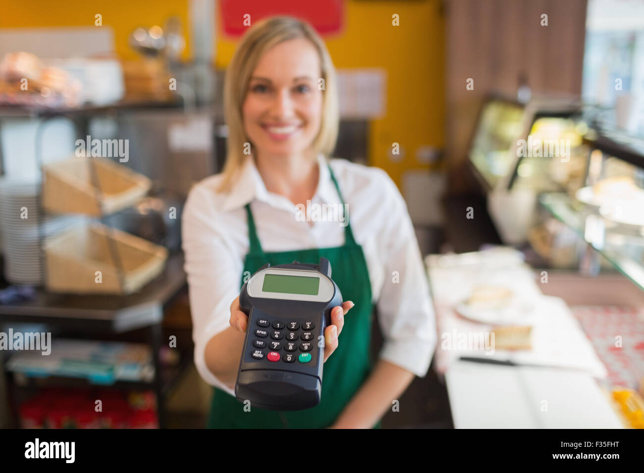 Weibliche Shopbetreiber halten Kreditkartenleser Stockfoto