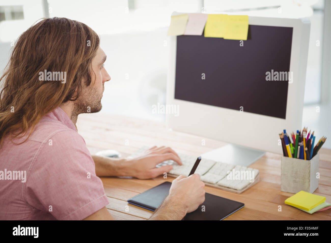 Mann arbeitet auf Computer mit Grafiktablett Stockfoto