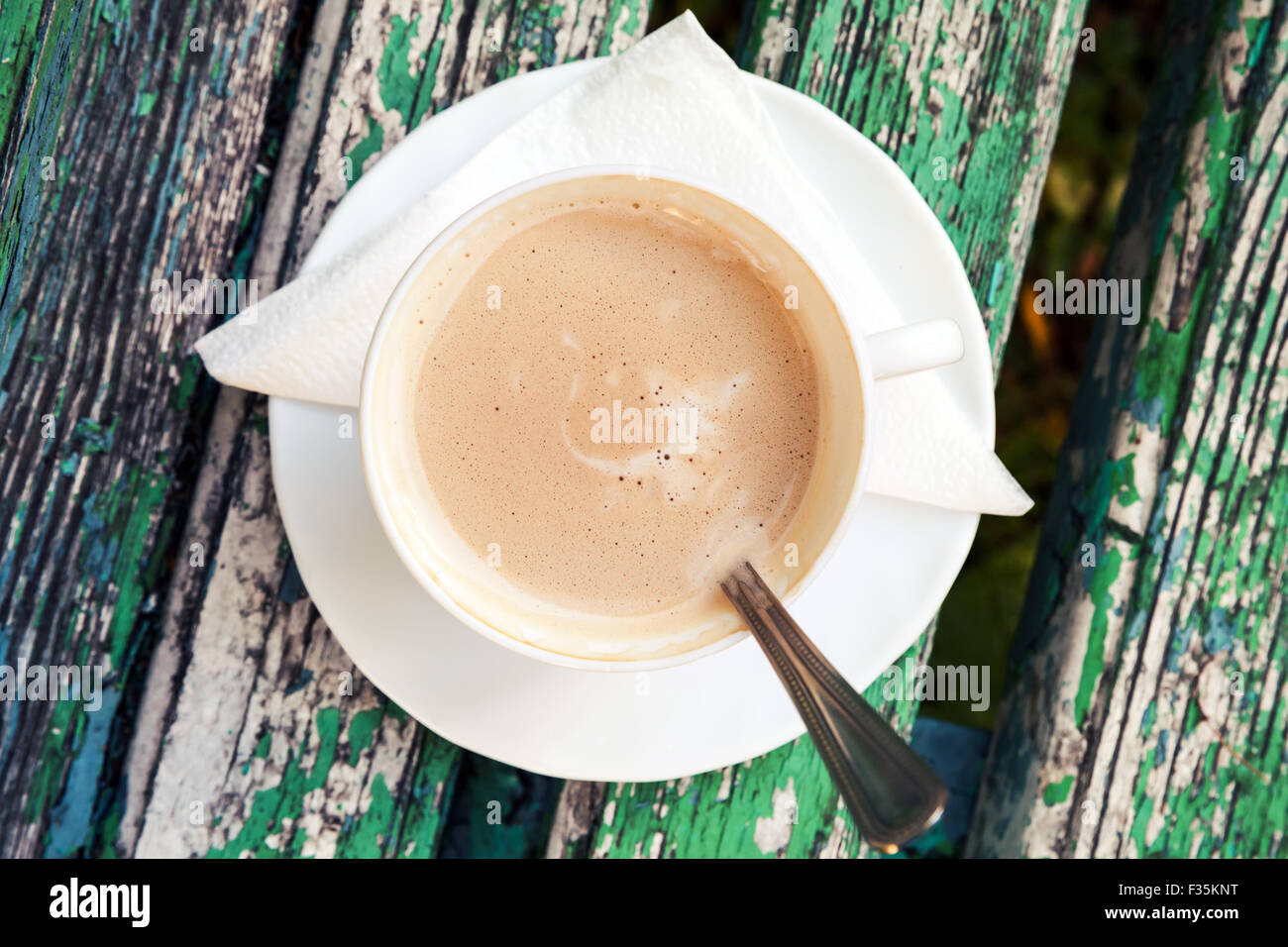 Tasse Kaffee mit Sahne ist auf alten Holzbank im Herbst Park.  Ansicht von oben, selektiven Fokus mit flachen DOF Stockfoto