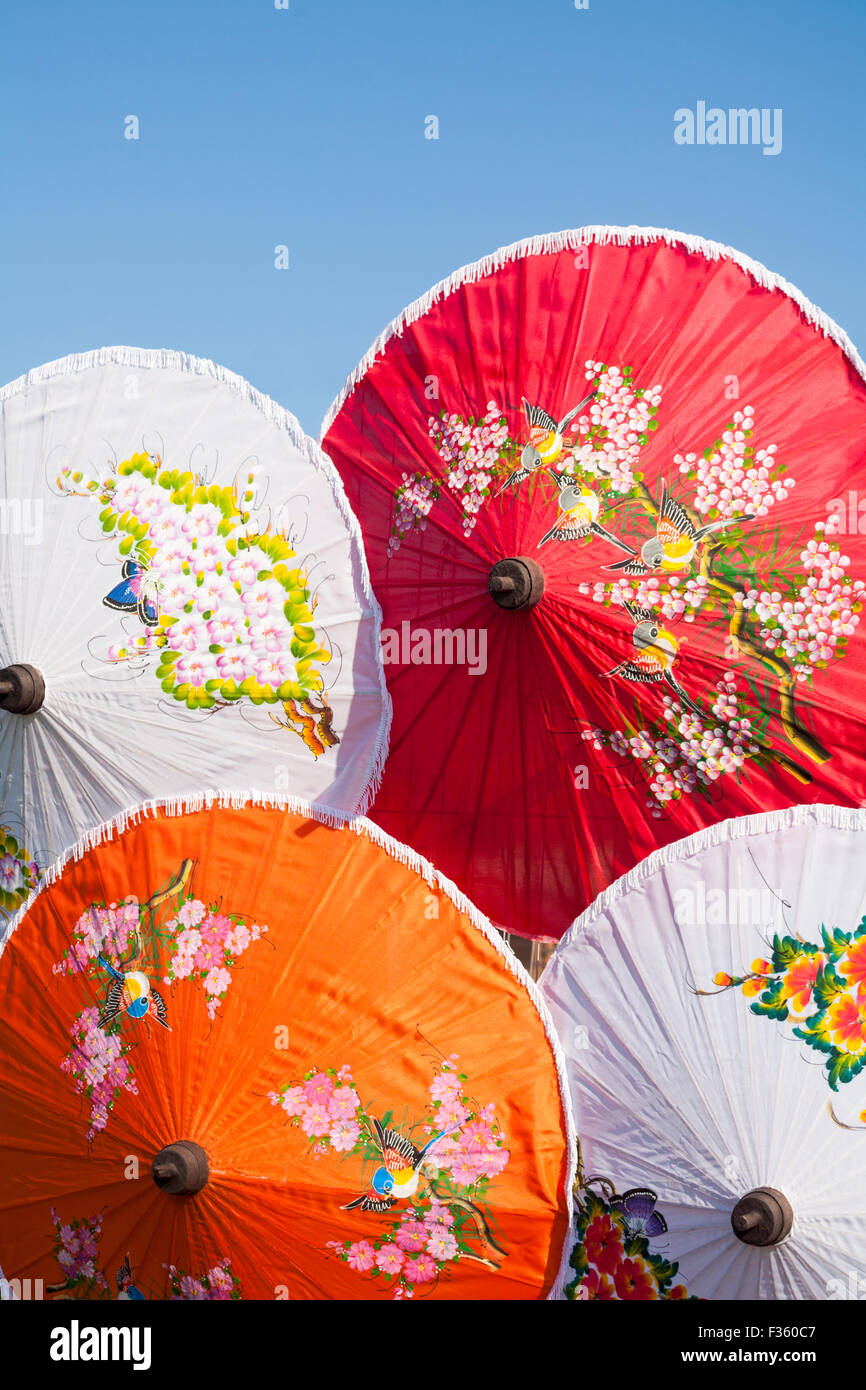 Bunte Sonnenschirme auf dem Poole Thai Festival, Dorset, UK im September stehen im Kontrast zum blauen Himmel Stockfoto