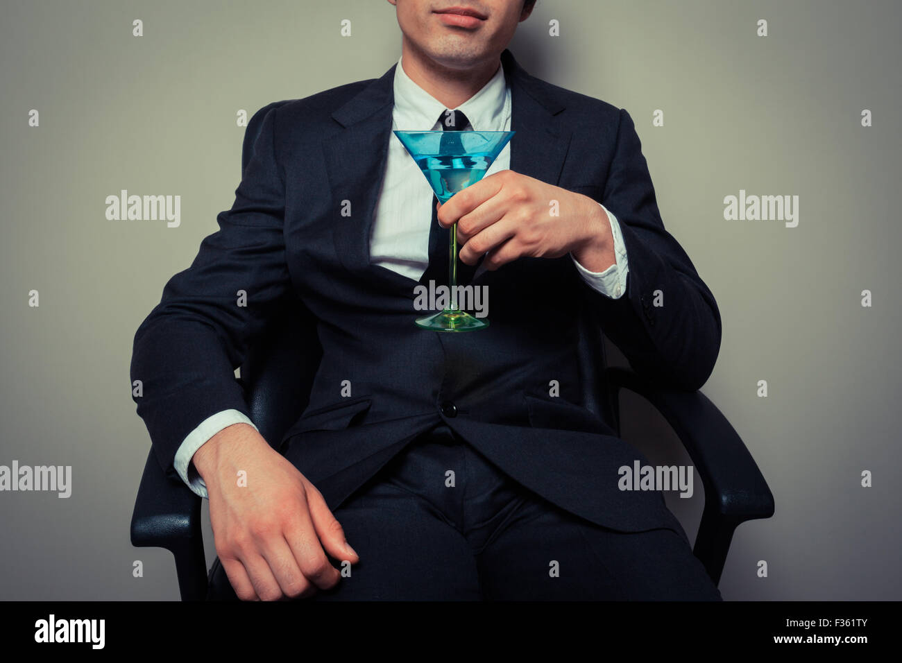 Junger Geschäftsmann, sitzen in einem Bürostuhl mit einem cocktail Stockfoto