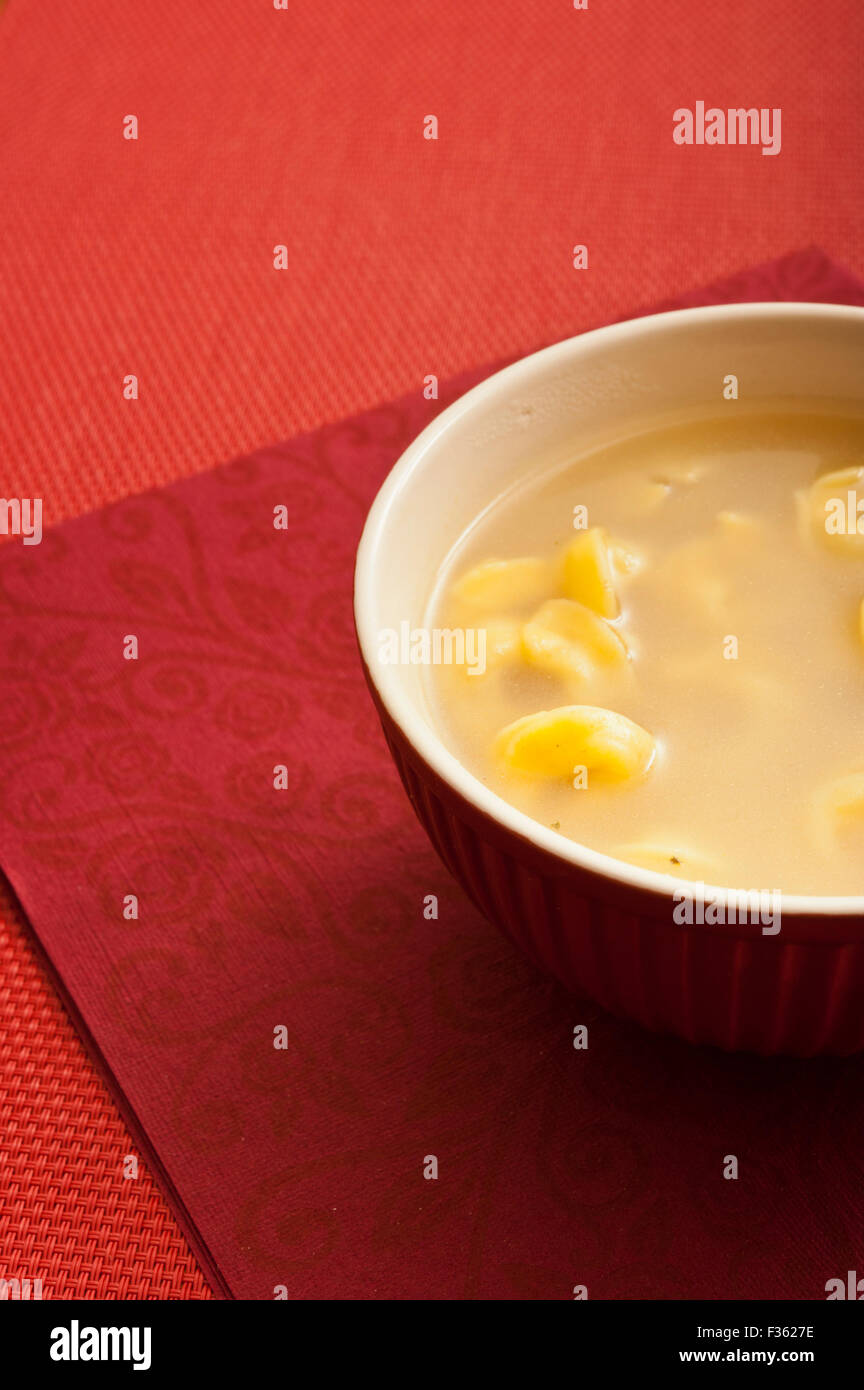Tortellini-Suppe in eine Schüssel geben Stockfoto