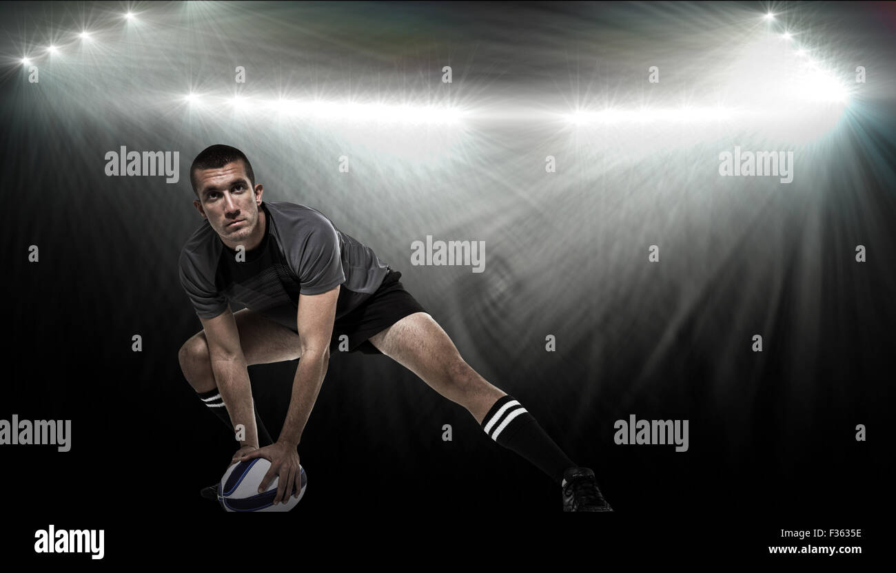 Zusammengesetztes Bild der Sportler in schwarzem Jersey stretching mit Kugel Stockfoto