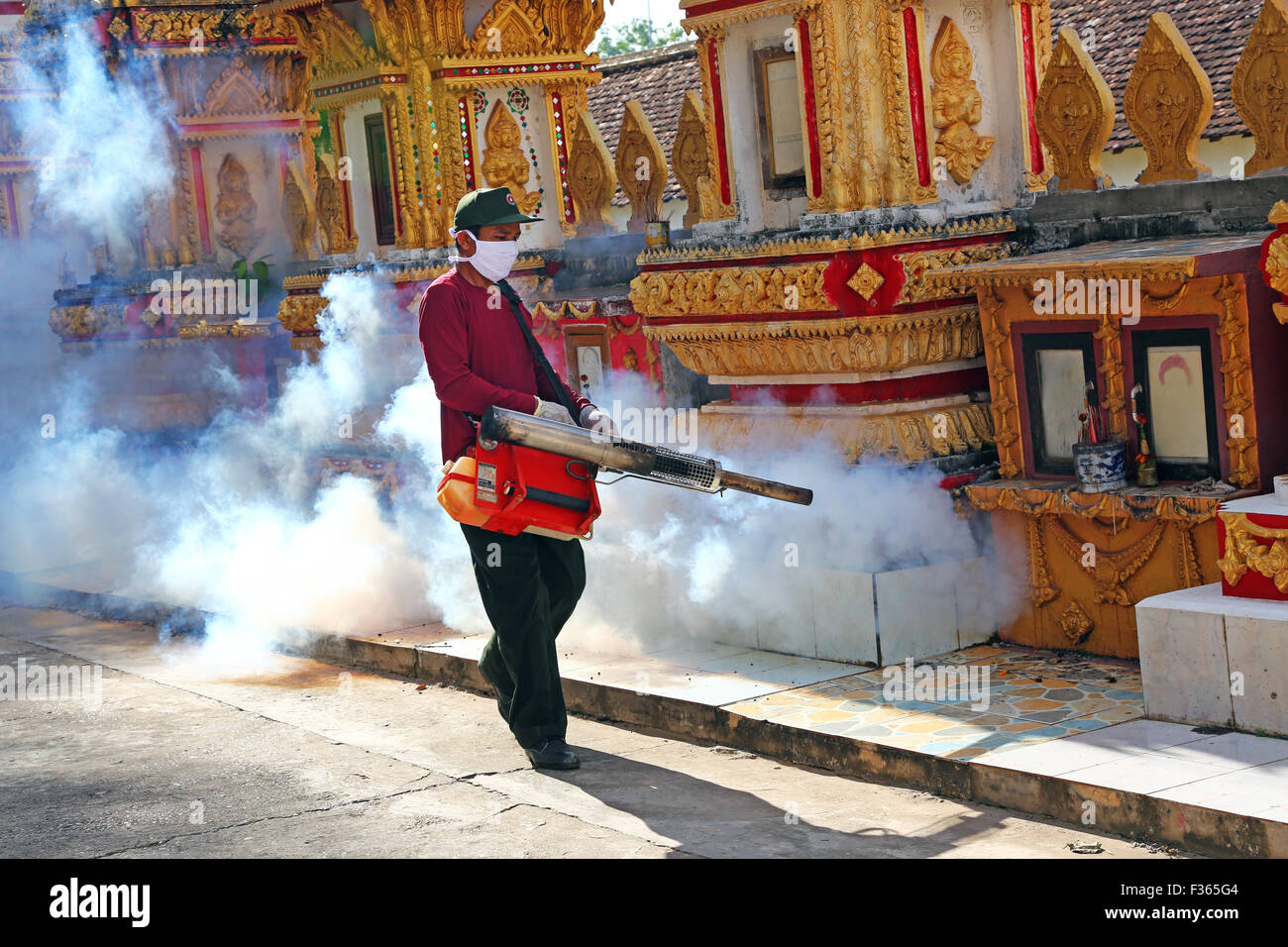 Reinigung des Tempels von Insekten mit Rauch in der Nähe, dass Luang Tempel Wat, Vientiane, Laos Stockfoto