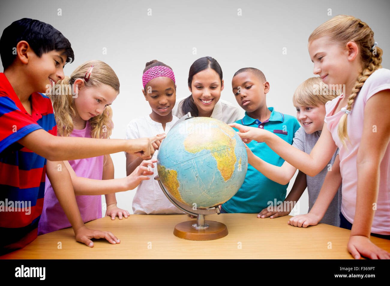 Zusammengesetztes Bild der niedlichen Schüler und Lehrer im Globe in Bibliothek suchen Stockfoto