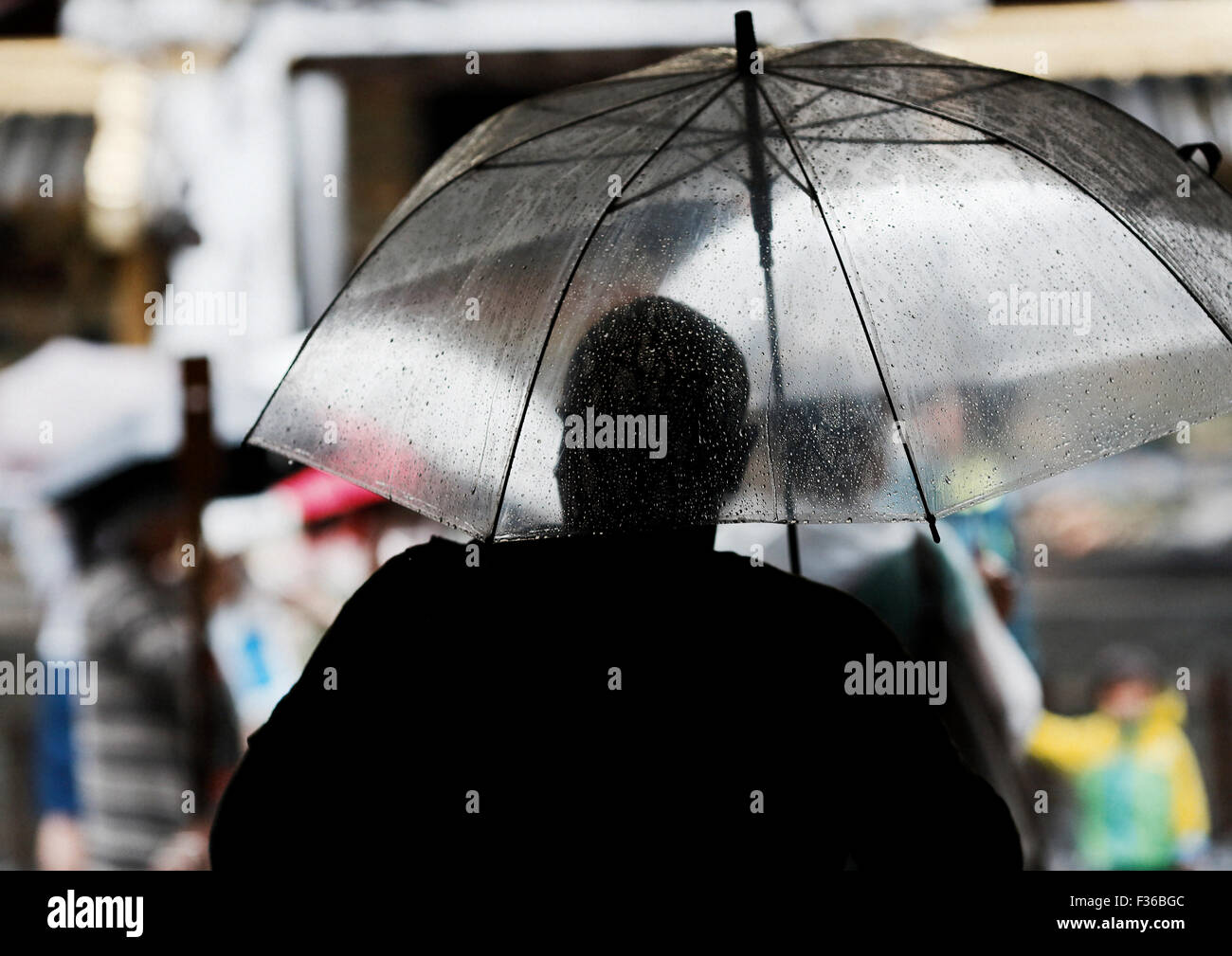 Silhouette des Mannes mit transparenter Regenschirm Stockfoto