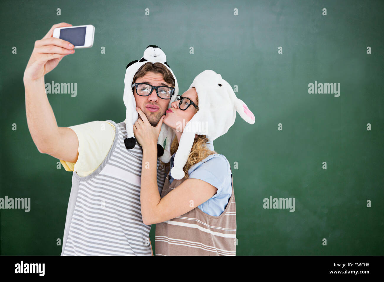 Zusammengesetztes Bild von geeky Hipster paar nehmen Selfie mit smartphone Stockfoto