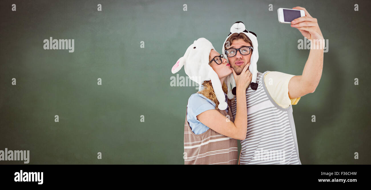 Zusammengesetztes Bild von geeky Hipster paar nehmen Selfie mit smartphone Stockfoto