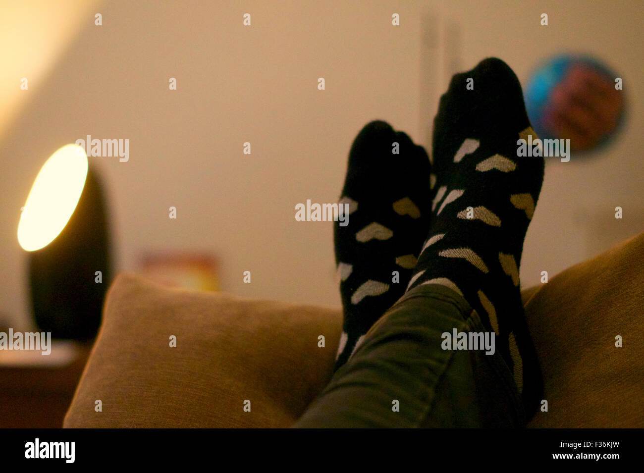 Füße mit Socken ruht auf Kissen, mit Licht im Hintergrund Stockfotografie -  Alamy