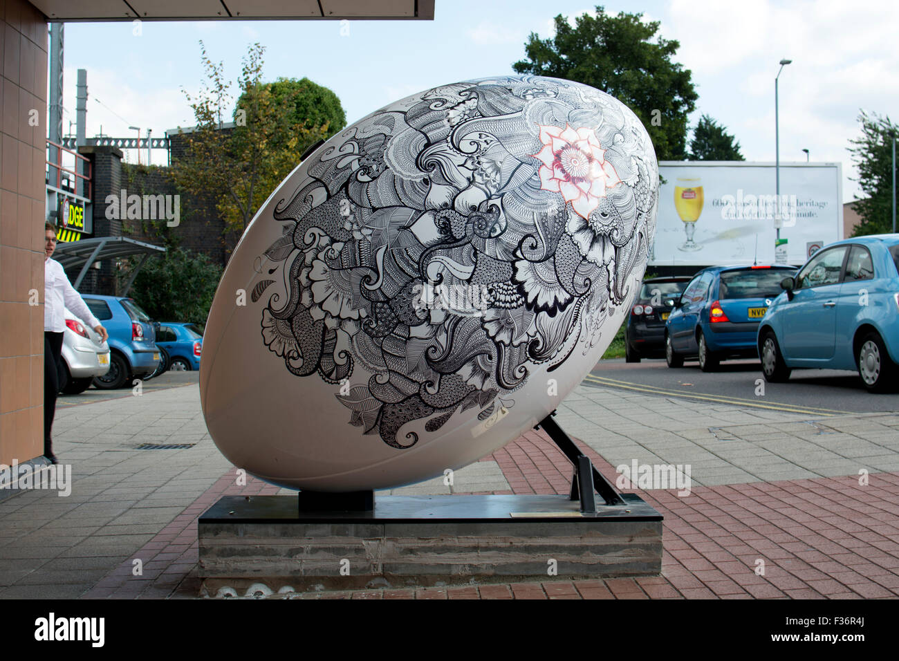 Rugby, Warwickshire, England, UK. 30. September 2015. Einem riesigen Rugbyball begrüßt Ankunft am Bahnhof von Rugby. Als Teil der Stadt Rugby Feier des Rugby World Cup 2015 wurden fünf riesigen Rugbybälle in exponierter Lage um die Stadt herum platziert. Das Display ist passenderweise den Titel "Rugby Got Balls". Bildnachweis: Colin Underhill/Alamy Live-Nachrichten Stockfoto