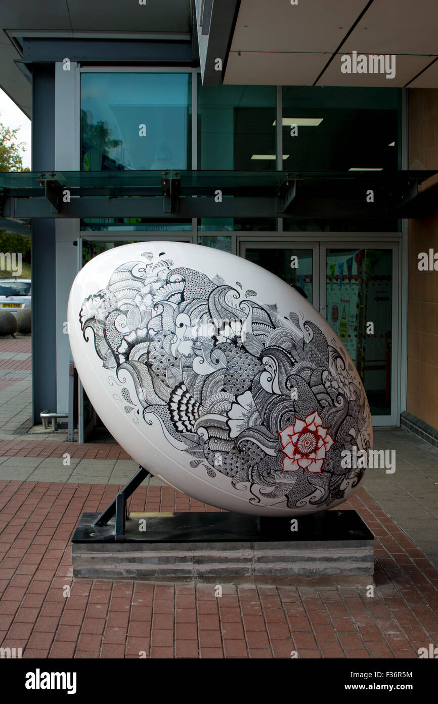 Rugby, Warwickshire, England, UK. 30. September 2015. Einem riesigen Rugbyball begrüßt Ankunft am Bahnhof von Rugby. Als Teil der Stadt Rugby Feier des Rugby World Cup 2015 wurden fünf riesigen Rugbybälle in exponierter Lage um die Stadt herum platziert. Das Display ist passenderweise den Titel "Rugby Got Balls". Bildnachweis: Colin Underhill/Alamy Live-Nachrichten Stockfoto
