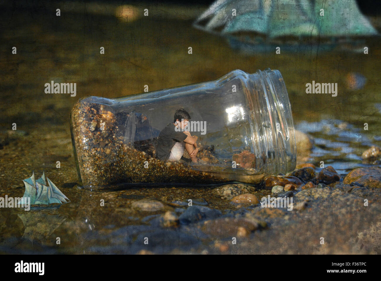 Junge in einer großen Flasche in Mitte des Wassers Stockfoto