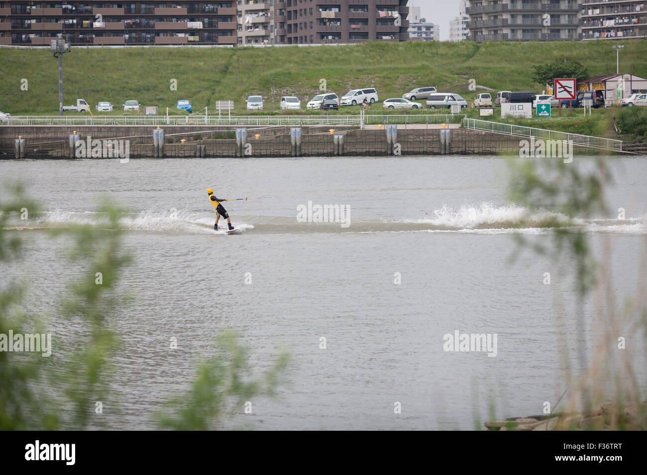 Mann auf Wasserski auf Linie Park im Hintergrund halten Stockfoto