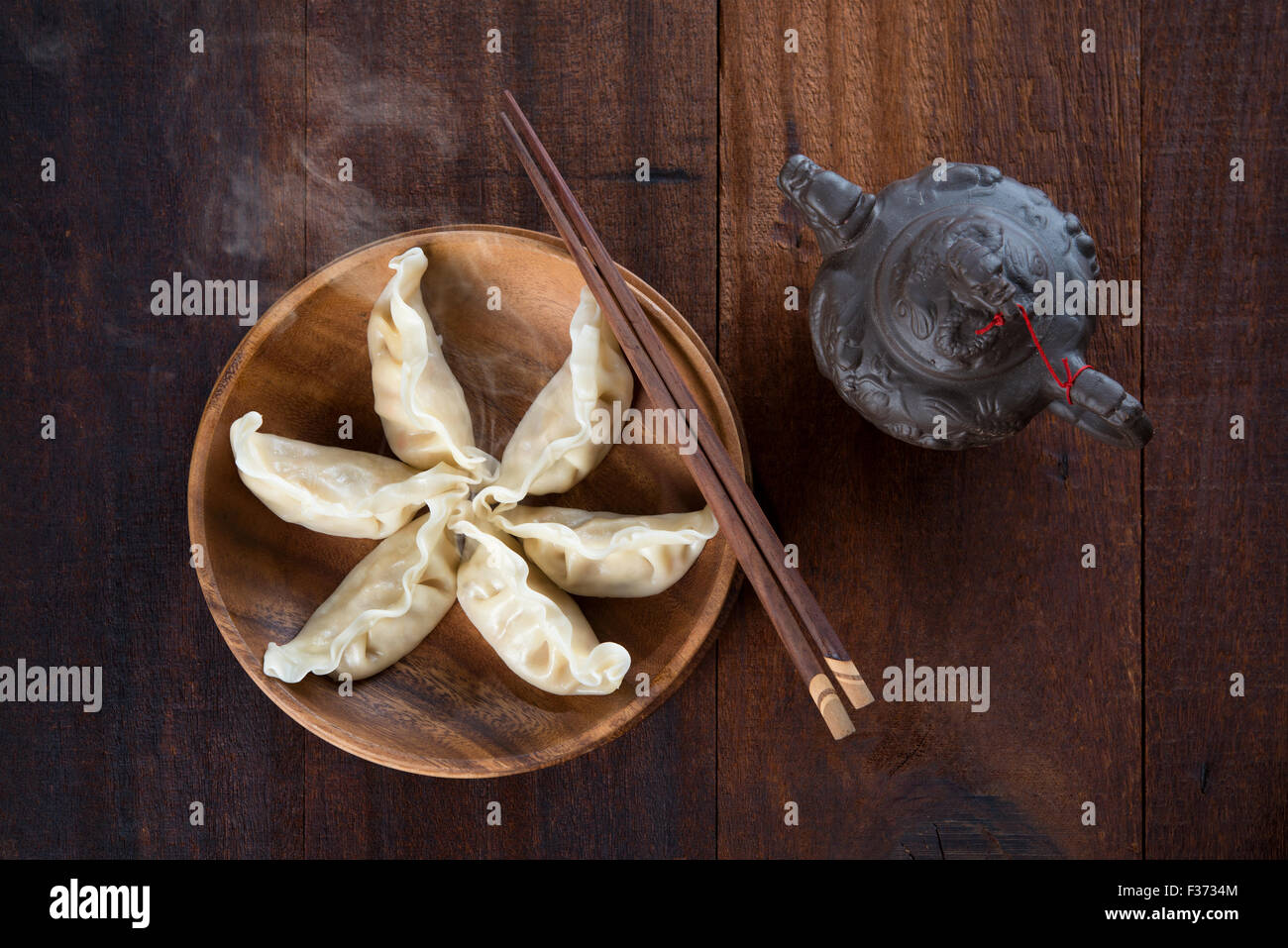 Ansicht von oben frische Knödel auf Holzplatte mit Stäbchen. Chinesisches Gericht auf rustikalen alten hölzernen Hintergrund. Stockfoto