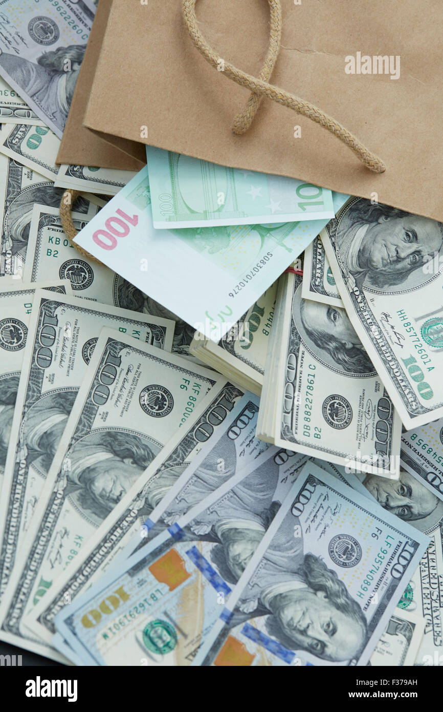 eine Menge Geld aus einer Papiertüte. Dollar und Euro Stockfoto