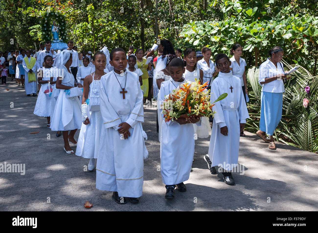 Kinder in weißer Kleidung, Männer tragen Mary-Figur auf einer Bahre, katholische Festival, Parade, Prozession auf den Urlaub von der Stockfoto