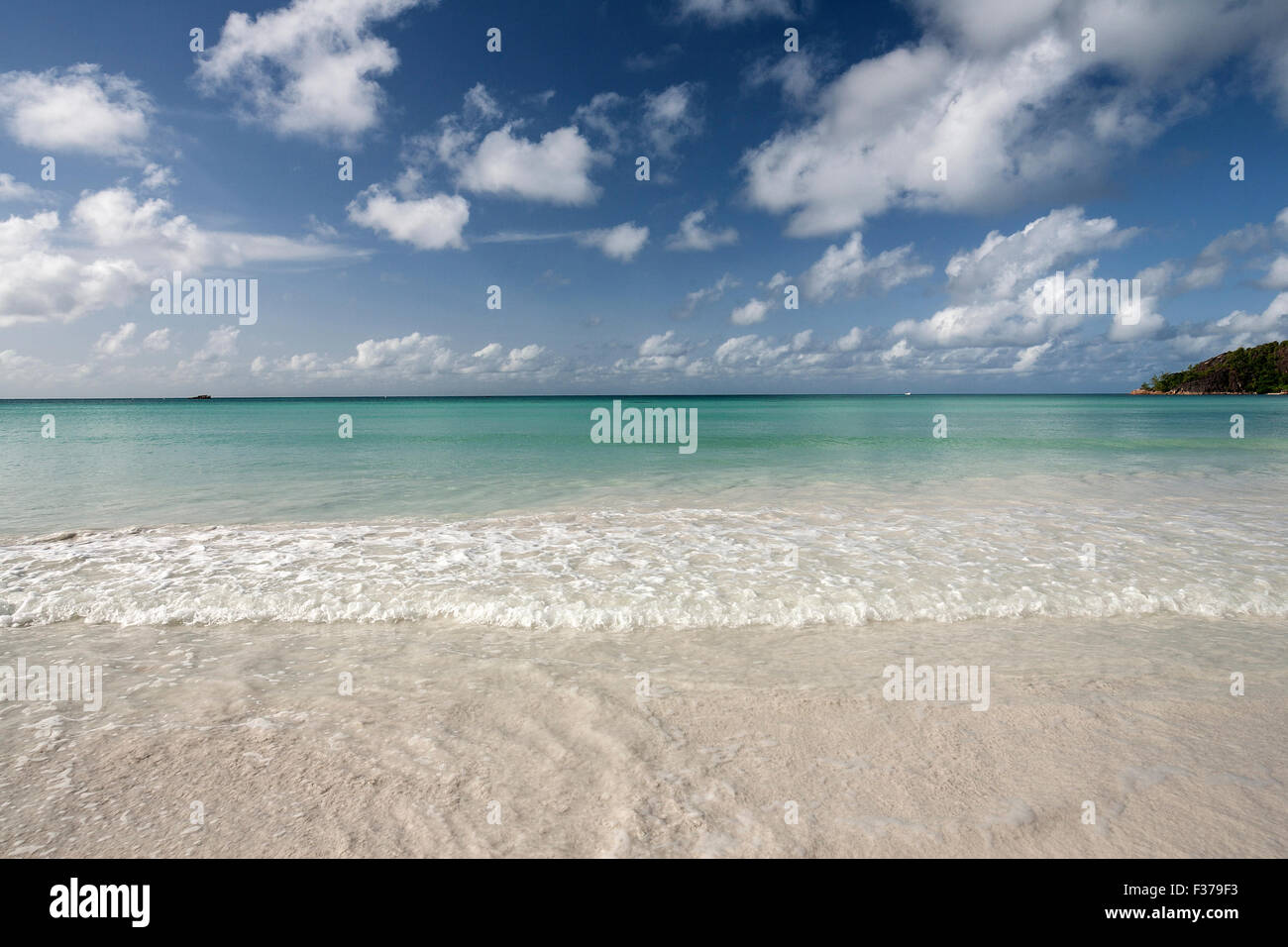 Weißen Sandstrand Anse Volbert, türkisfarbenes Wasser, blauer Himmel mit Wolken, Indischer Ozean, Insel Praslin, Seychellen Stockfoto