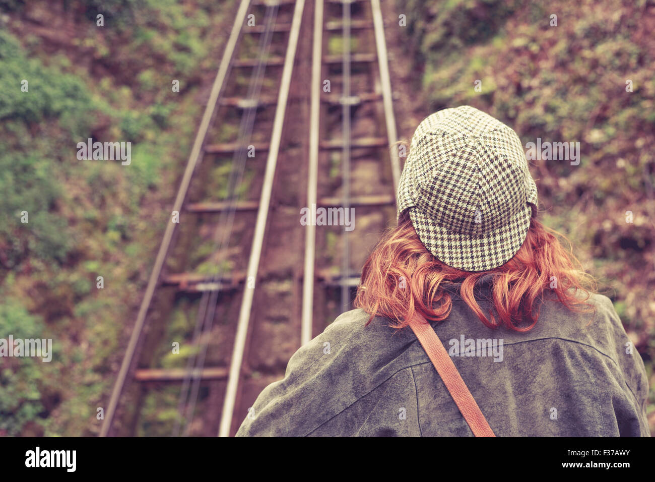 Rückansicht einer jungen Frau, die auf einer Klippe-Schiene Stockfoto