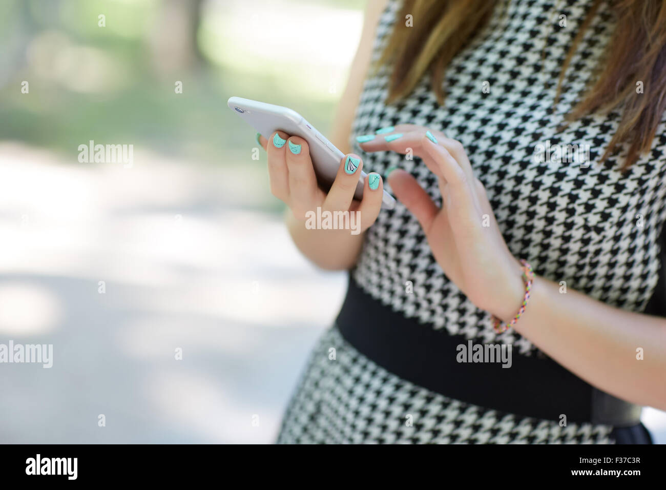 Nahaufnahme eines Mädchens in einem Park ist ein Handy halten. Stockfoto