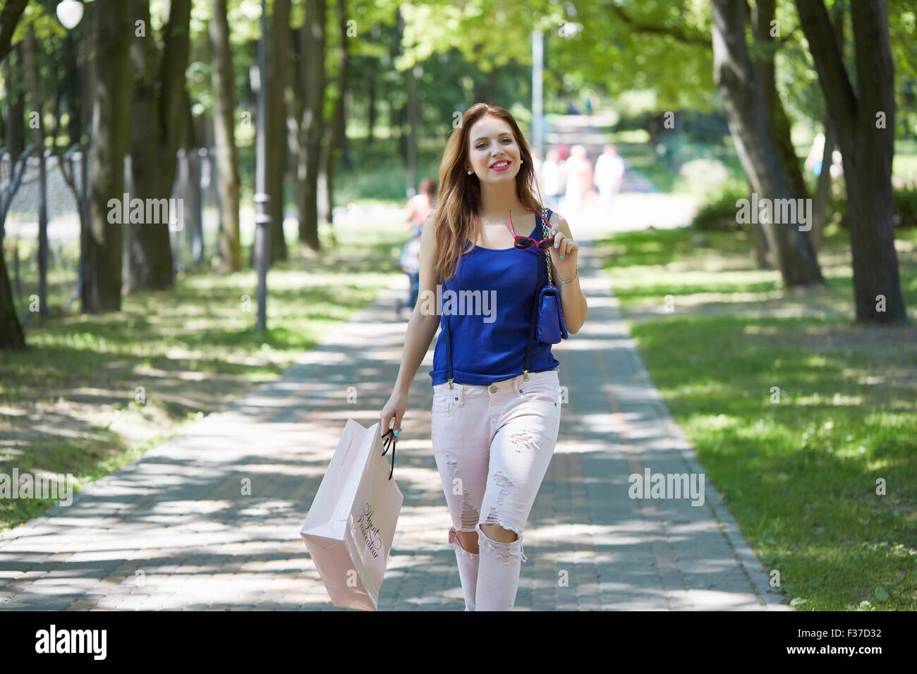 schöne Mädchen in den Park mit Einkaufstasche Stockfoto