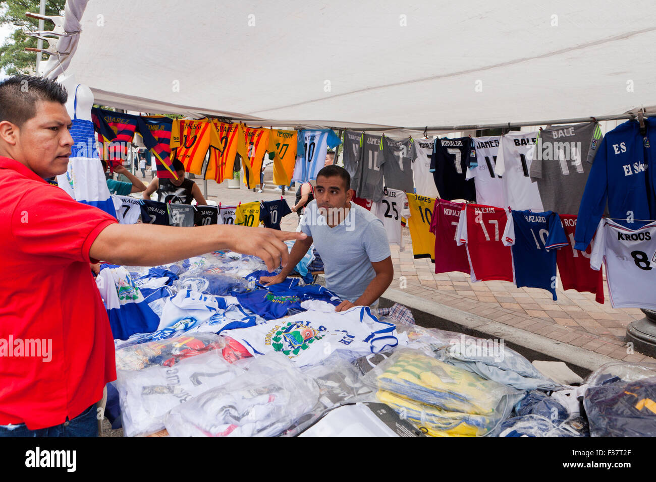 Mann, Kommissionierung Trikot im Fussball Kleidung Zelt bei einem Outdoor-Festival - USA Stockfoto