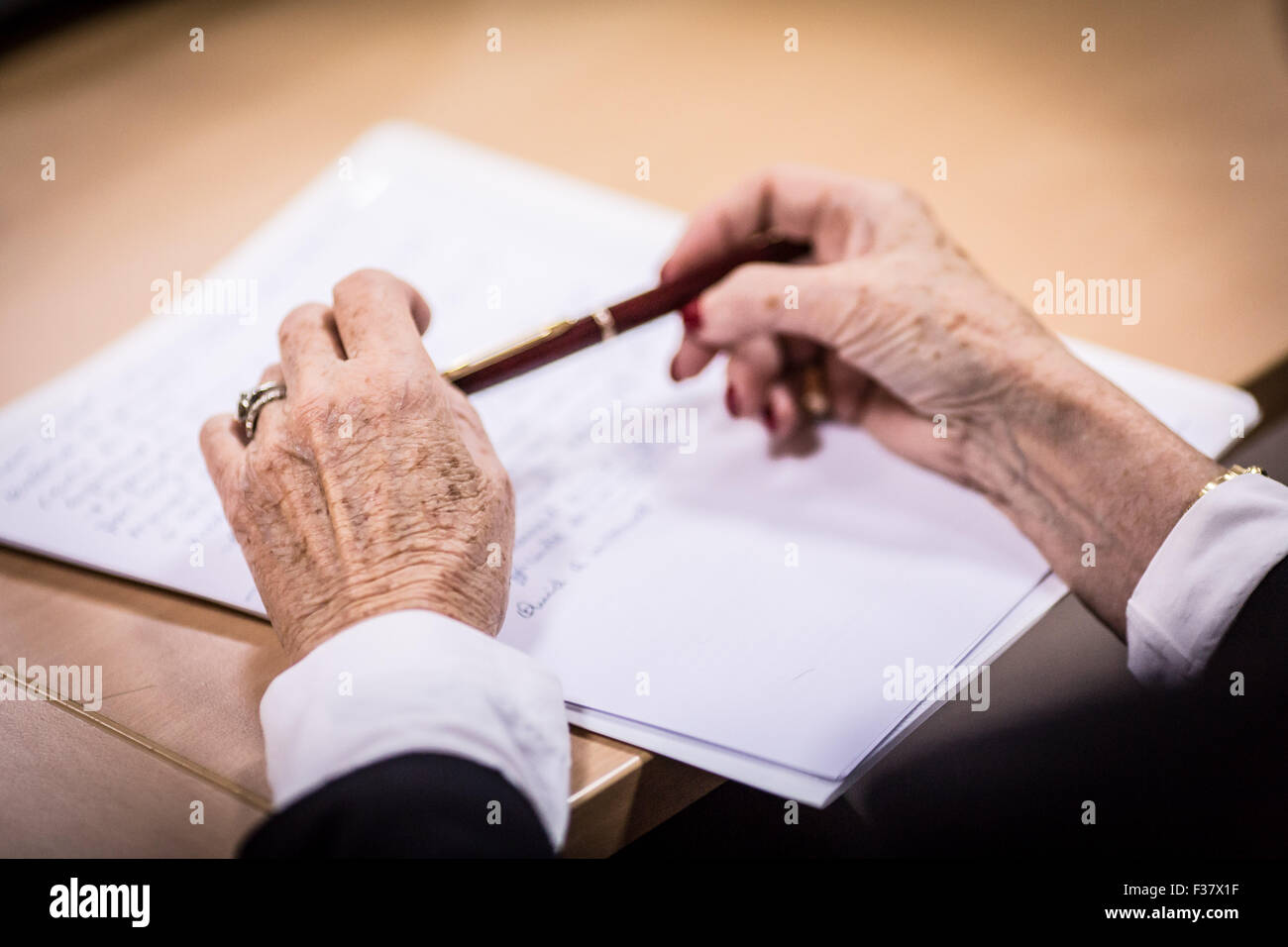 Hände einer älteren Frau hält einen Stift. Stockfoto