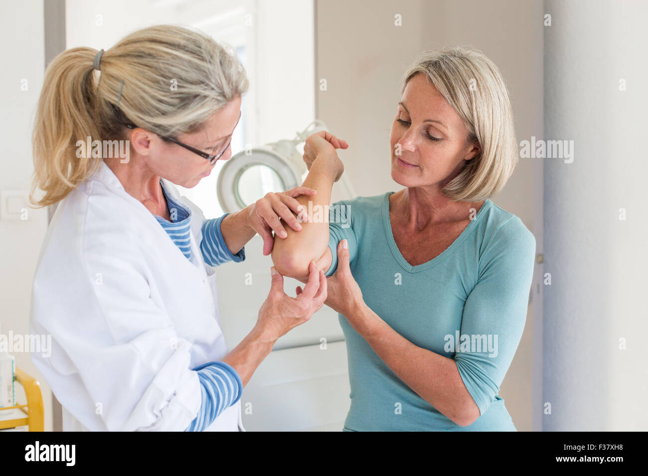 Arzt untersucht die Haut einer Frau. Stockfoto
