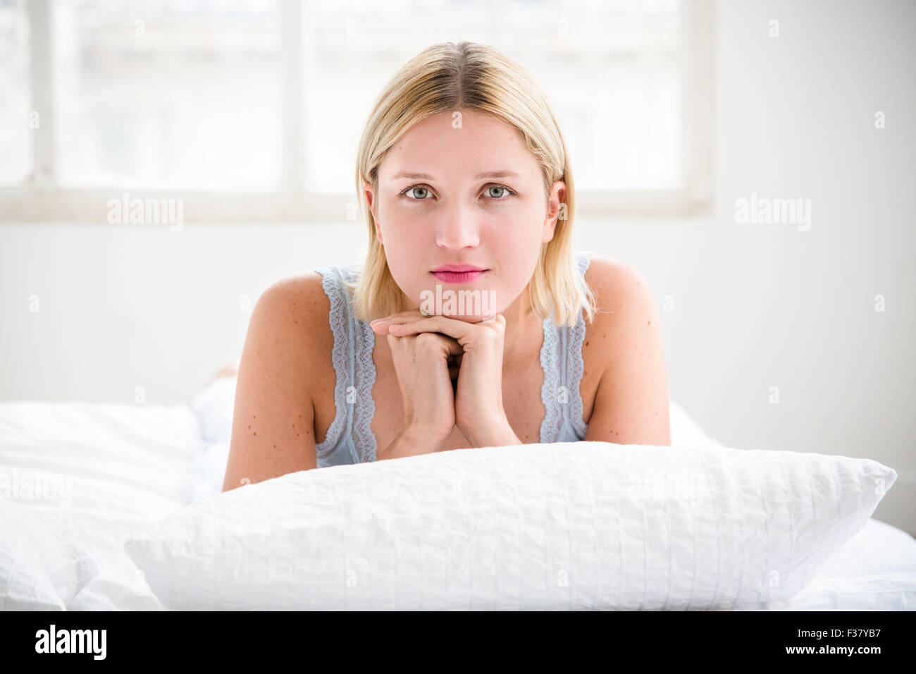 Junge Frau im Bett liegend. Stockfoto