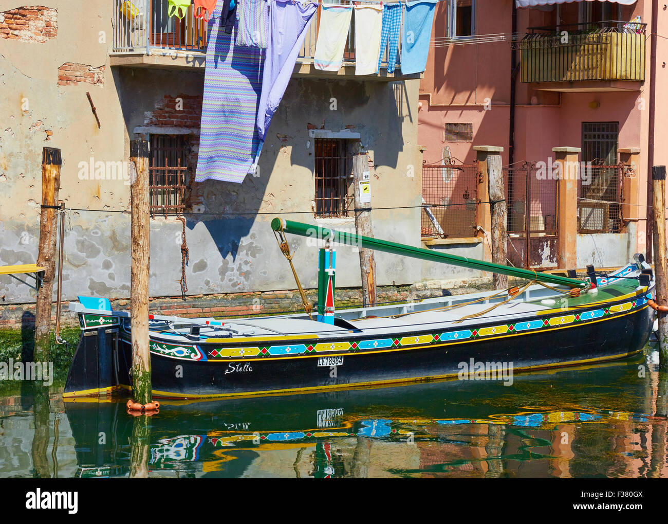 Bunte Schiff vertäut unter Canalside Apartments mit waschen hängen Chioggia venezianischen Lagune Veneto Italien Europa Stockfoto