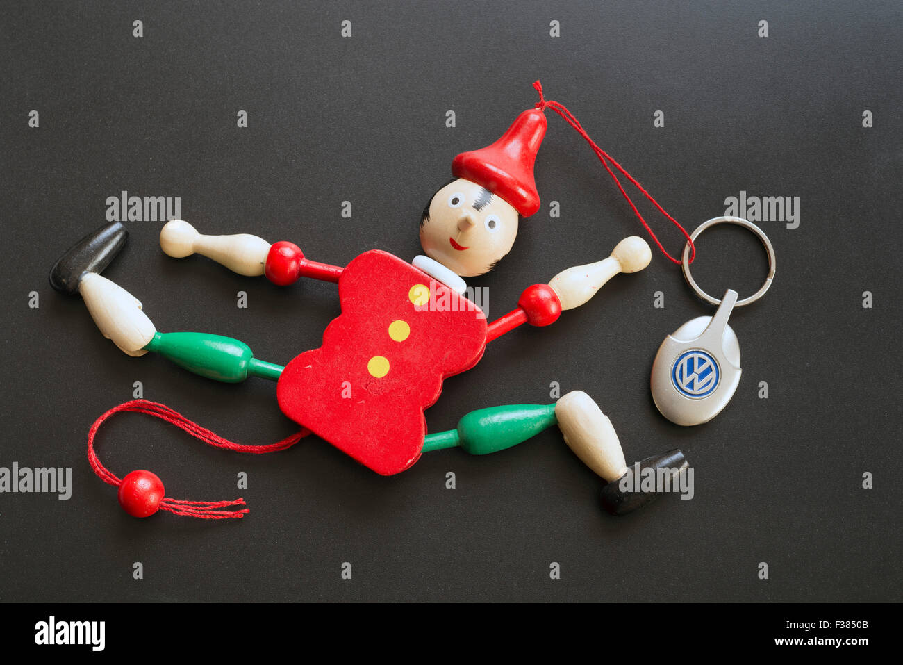 MADRID, Spanien - 30. September 2015: Schlüsselanhänger mit dem Logo des Automobilherstellers Volkswagen mit einer Marionette Pinocchio. schwarzem Hintergrund Stockfoto