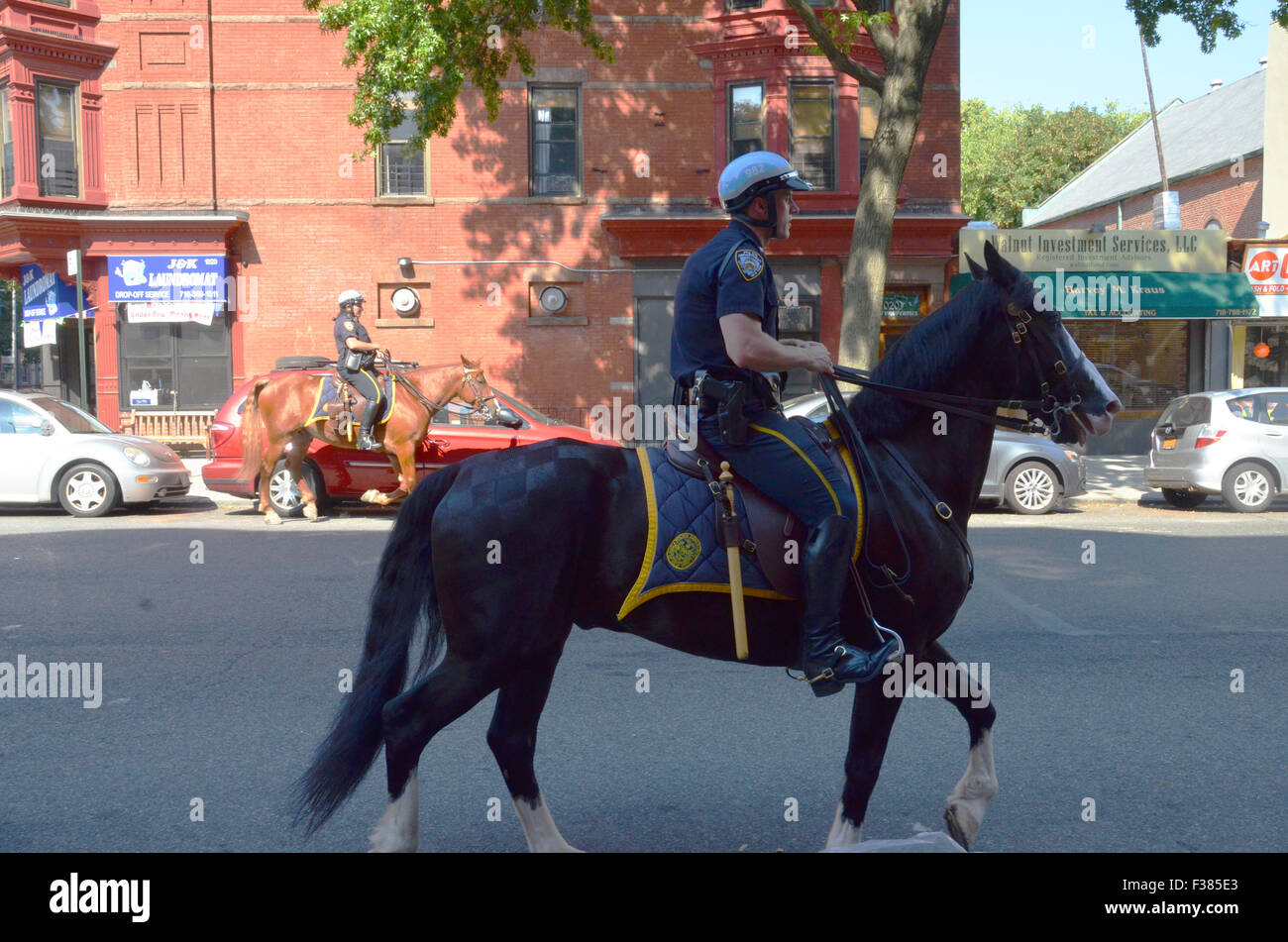 Ein Polizist auf einem Pferd reitet durch new york street Brooklyn Stockfoto