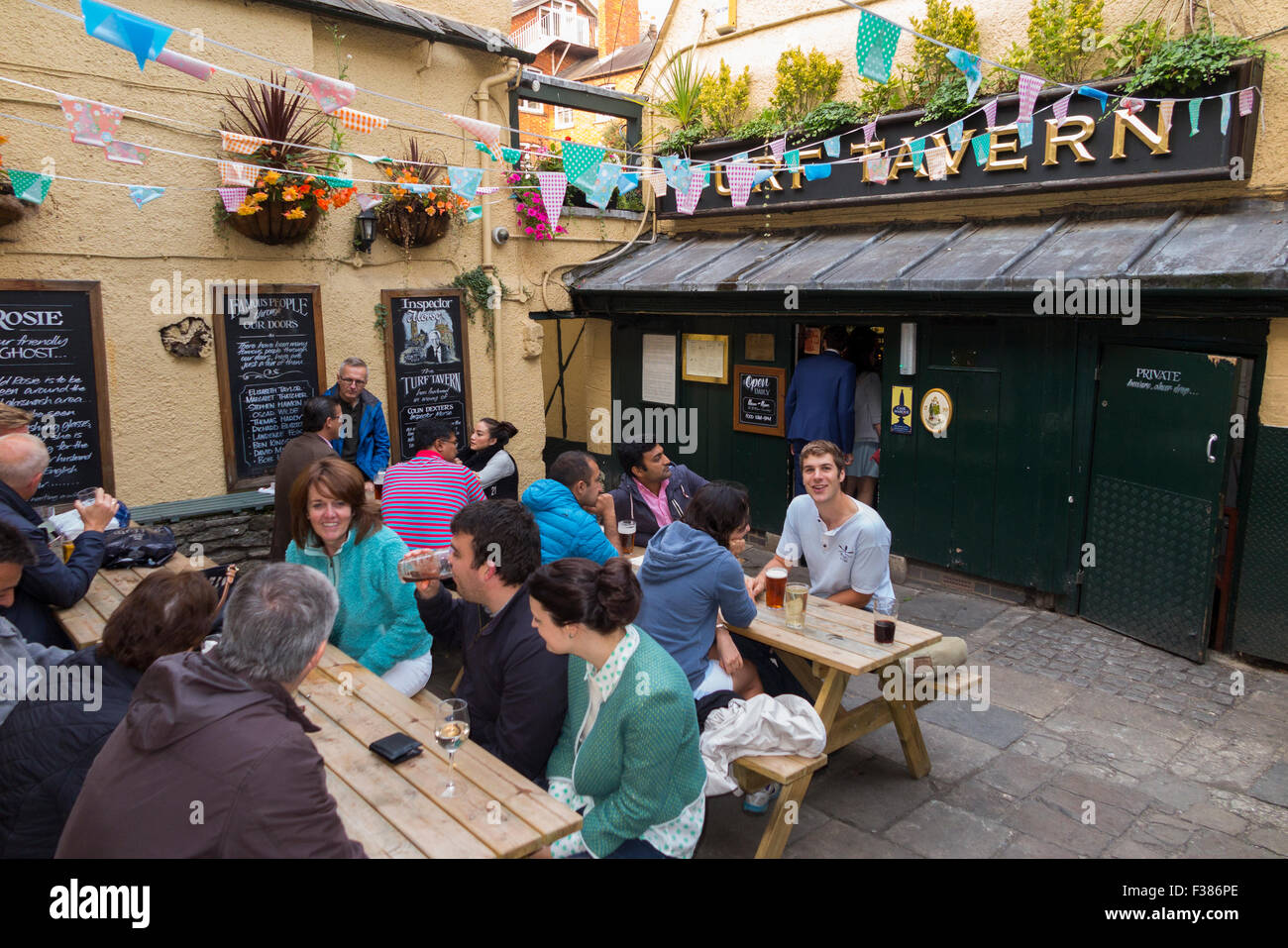 Gönner, Studenten, Trinker und Diners, genießen Sie warme Sommerwetter außerhalb der Gastwirtschaft Turf Tavern in Oxford. 4-5 Bad Platz, Oxford OX1 3SU. UK Stockfoto