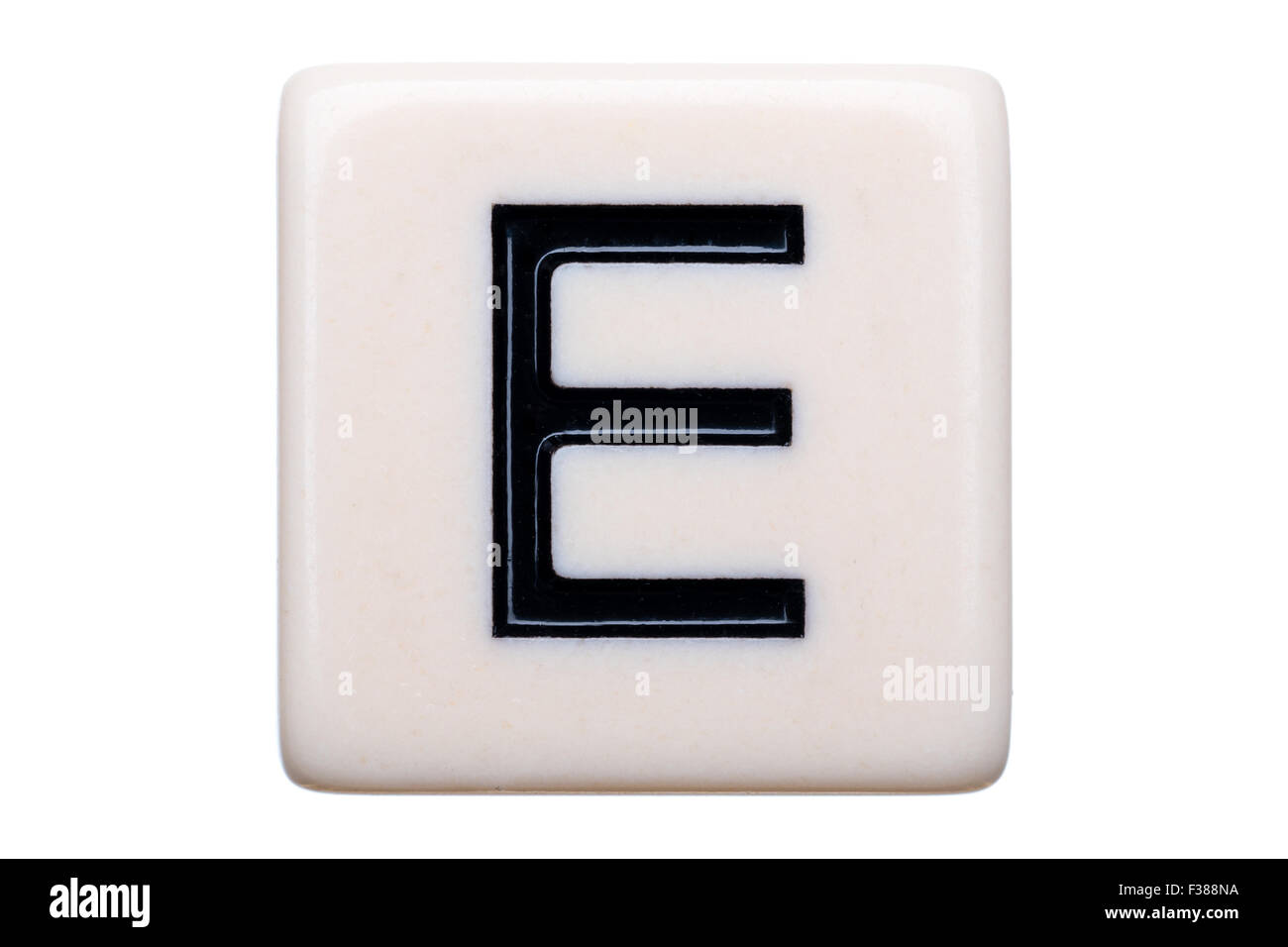 Eine Makroaufnahme einer Spiel Kachel mit dem Buchstaben E drauf auf einem weißen Hintergrund. Stockfoto