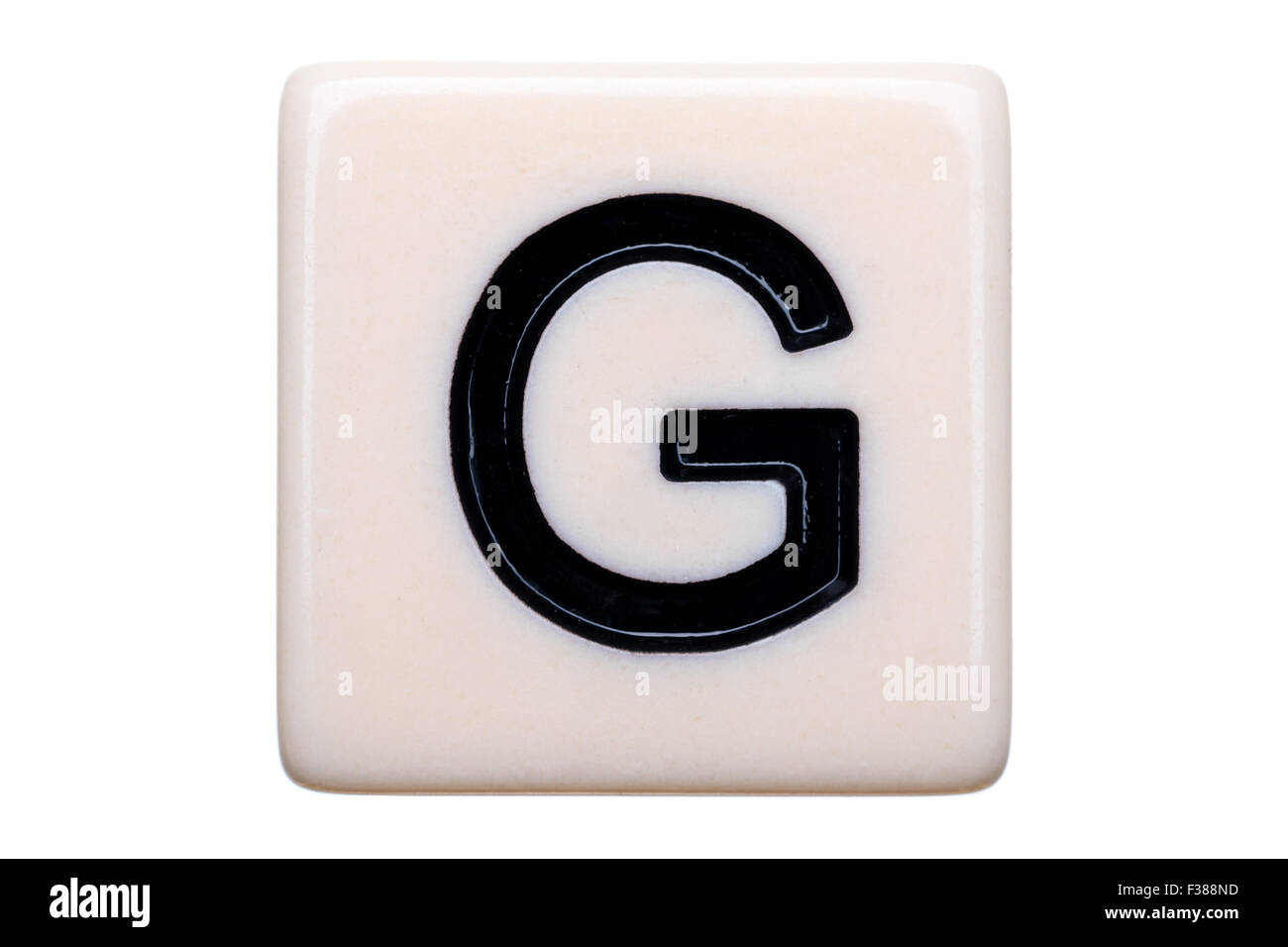Eine Makroaufnahme einer Spiel Kachel mit dem Buchstaben G drauf auf einem weißen Hintergrund. Stockfoto