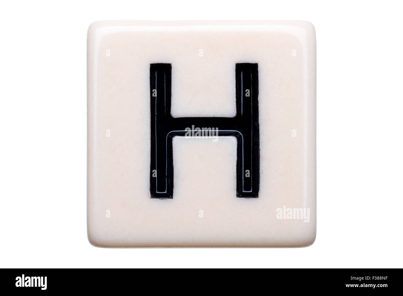 Eine Makroaufnahme einer Spiel Kachel mit dem Buchstaben H drauf auf einem weißen Hintergrund. Stockfoto