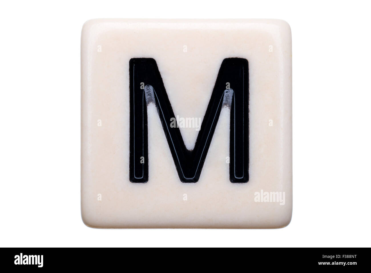 Eine Makroaufnahme einer Spiel Kachel mit dem Buchstaben M drauf auf einem weißen Hintergrund. Stockfoto
