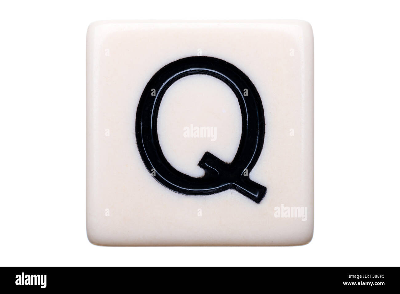 Eine Makroaufnahme einer Spiel Kachel mit dem Buchstaben Q drauf auf einem weißen Hintergrund. Stockfoto