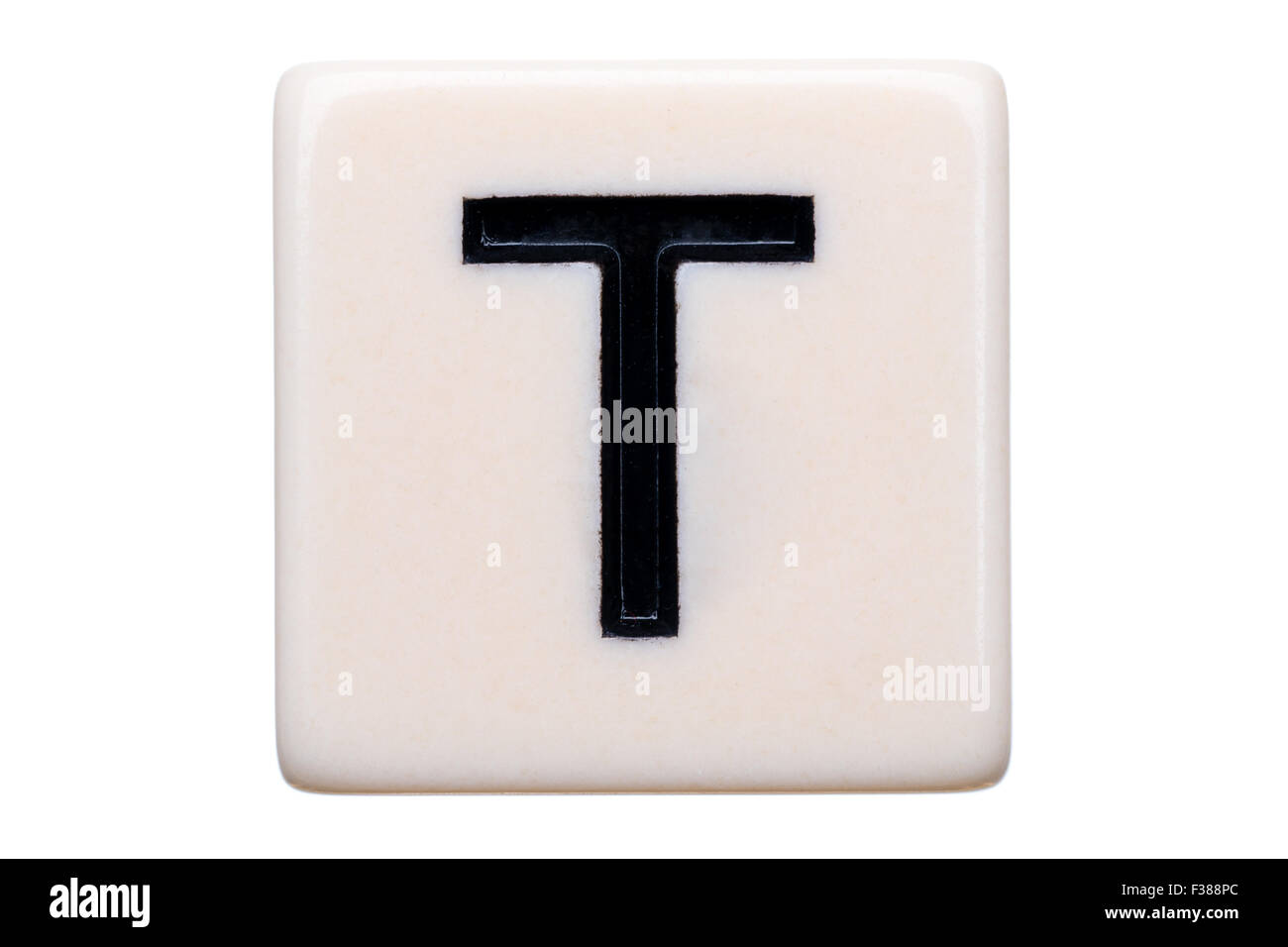 Eine Makroaufnahme einer Spiel Kachel mit dem Buchstaben T drauf auf einem weißen Hintergrund. Stockfoto
