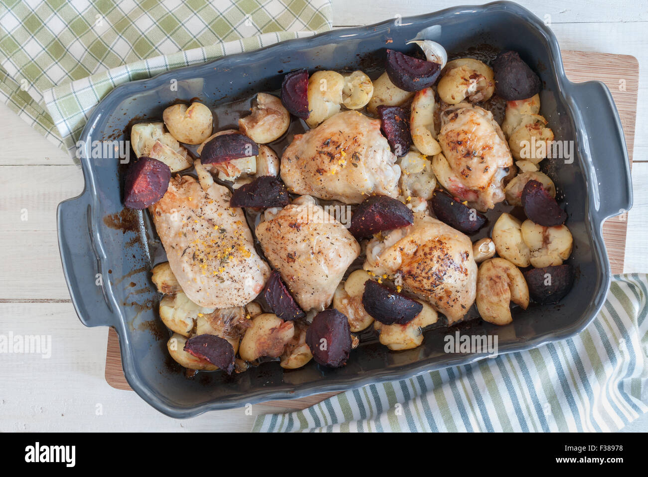 Gerösteter Zitrone und Thymian Hähnchenschenkel mit Knoblauch zerdrückt neue Kartoffeln und rote Beete in Balsamico-Essig und Olivenöl Stockfoto