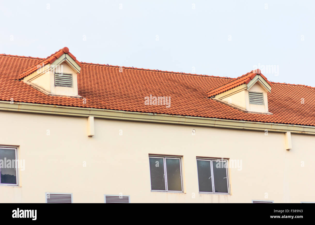 Schornsteine auf dem Dach des roten Ziegeln mit blauen Himmel und Wolken. Stockfoto